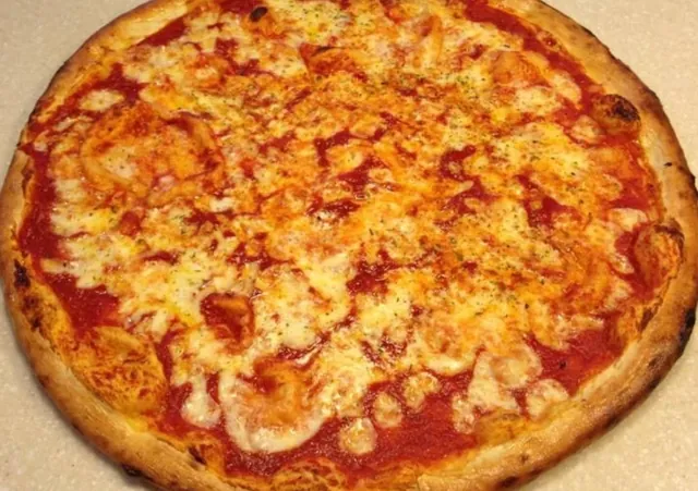 Detail pizze Margherita s opečeným okrajom a roztopenou mozzarellou na paradajkovom základe